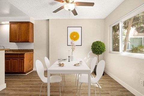 a dining room with a white table and chairs and a ceiling fan at White Oak Terrace Apartments, Encino, 91316