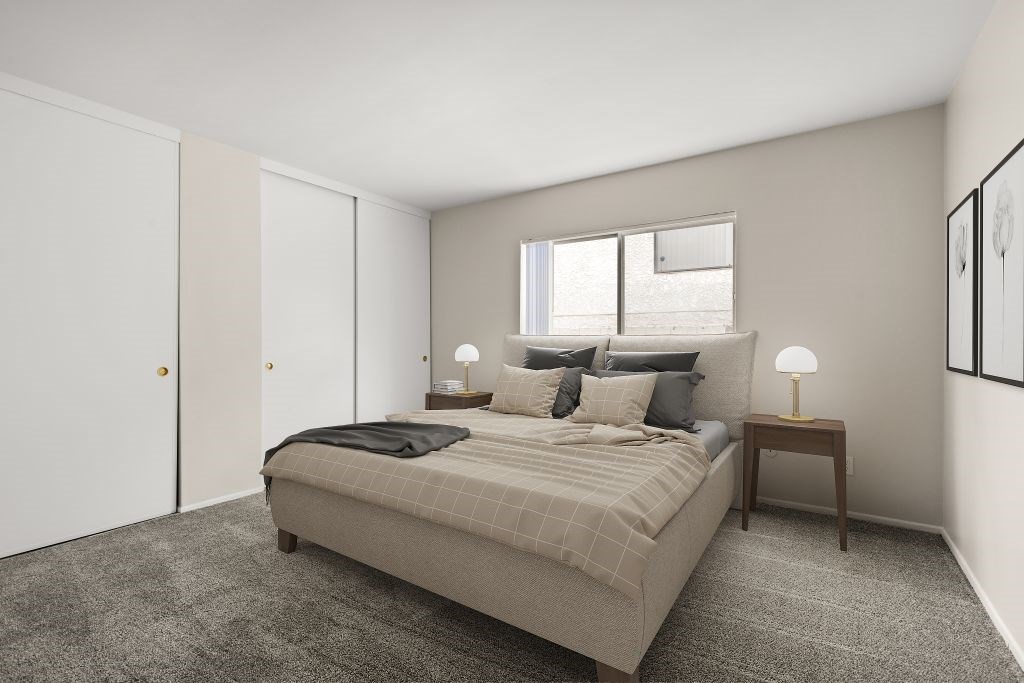 A bedroom with a bed, nightstands, and a window.