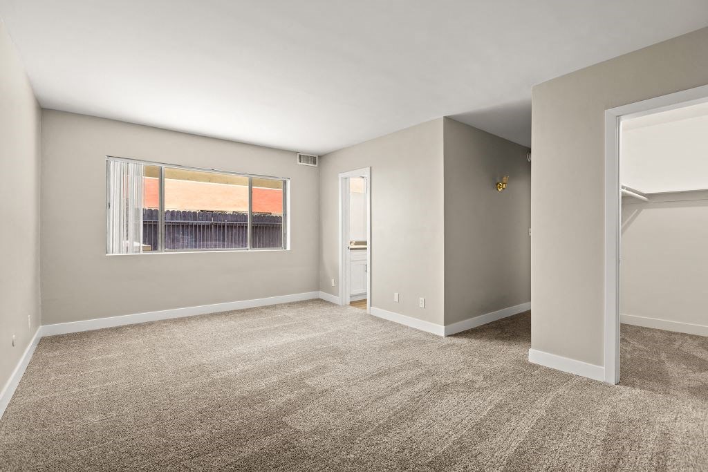 an empty bedroom with a large window