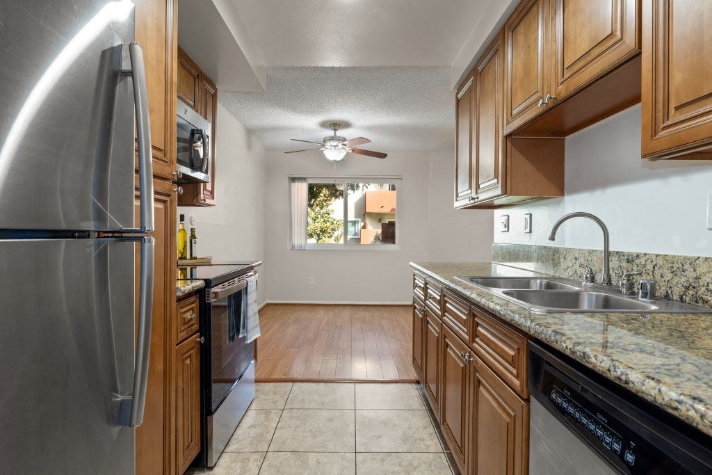 a kitchen with stainless steel appliances and wooden cabinets at Lombardi Apartments, Woodland Hills, 91367
