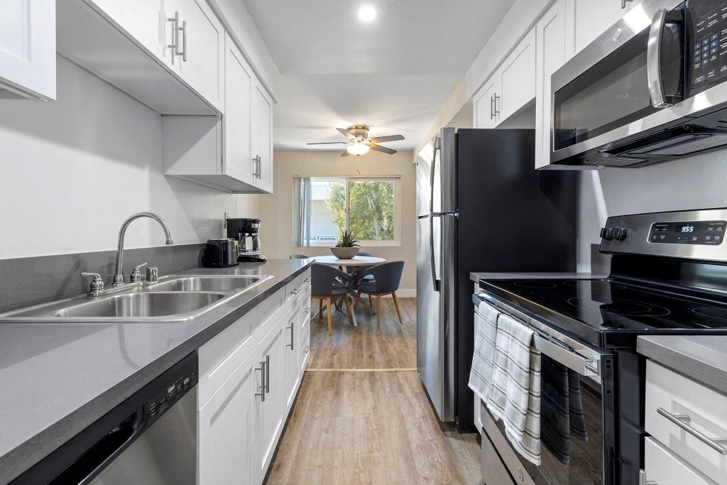 a kitchen with white cabinets and black appliances at Lombardi Apartments, Woodland Hills, CA, 91367