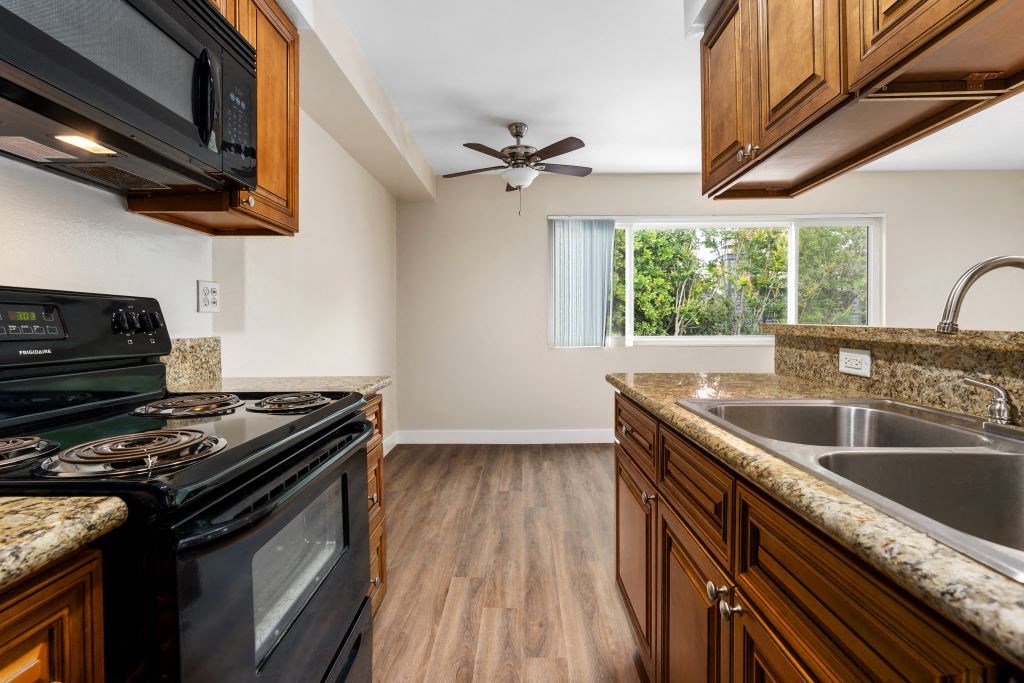 a kitchen with a stove top oven next to a sink