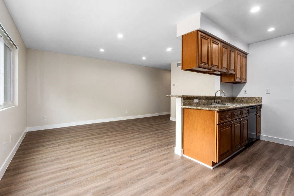 a kitchen and living room with wood floors and white walls