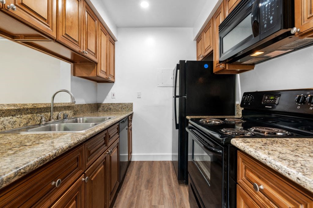 a kitchen with wood cabinets and black appliances at Lombardi Apartments, Woodland Hills, CA, 91367