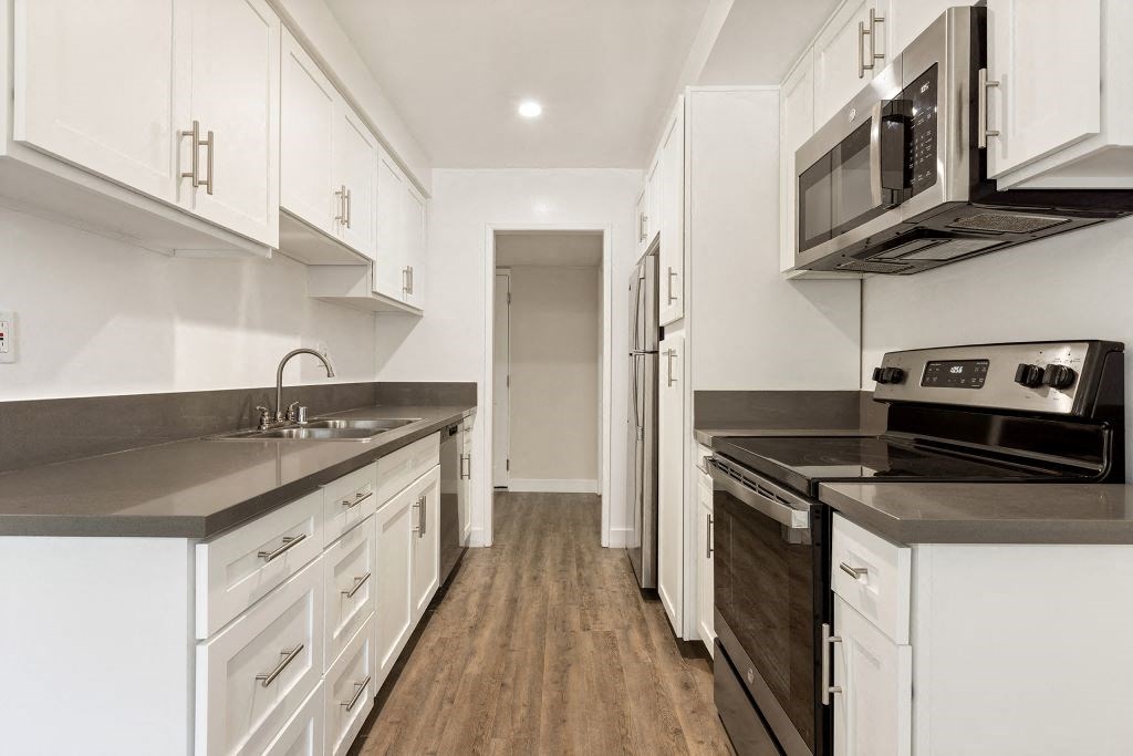 a kitchen with white cabinets and stainless steel appliances at Lombardi Apartments, Woodland Hills, California