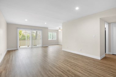 a living room with hardwood floors and white walls