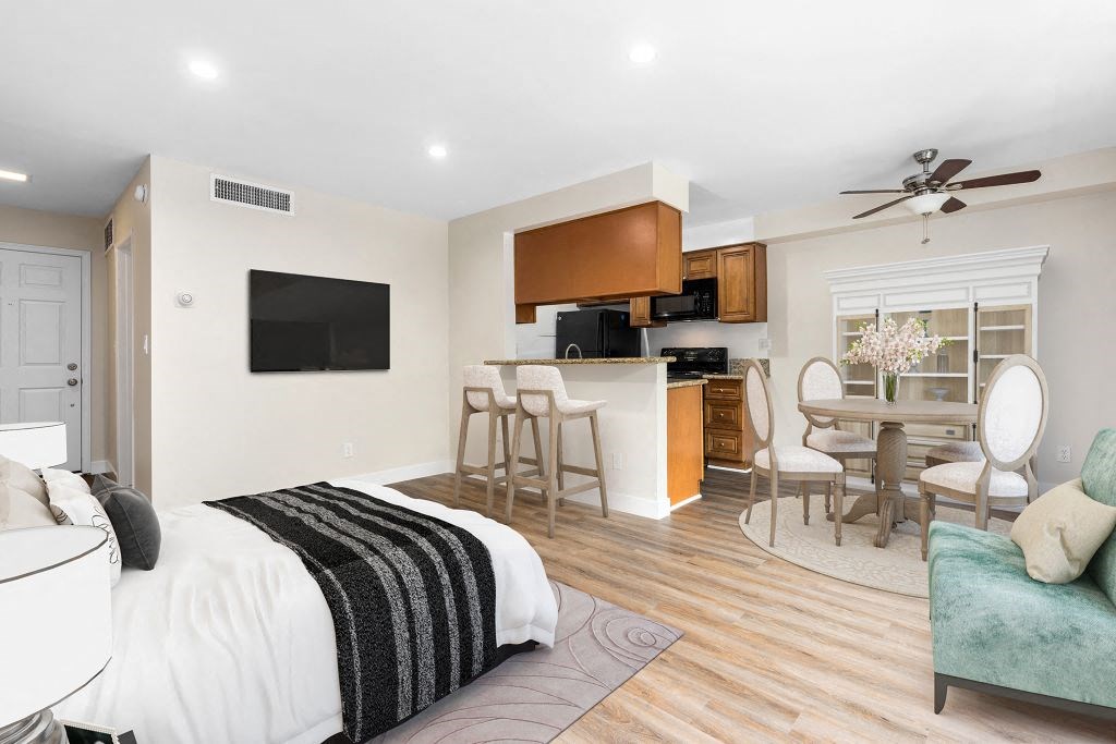 a bedroom with a bed and a kitchen with a table and chairs at Lombardi Apartments, Woodland Hills, CA, 91367