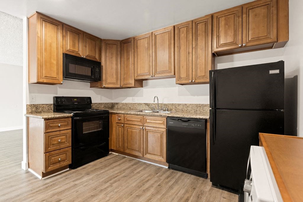 a kitchen with black appliances and wooden cabinets