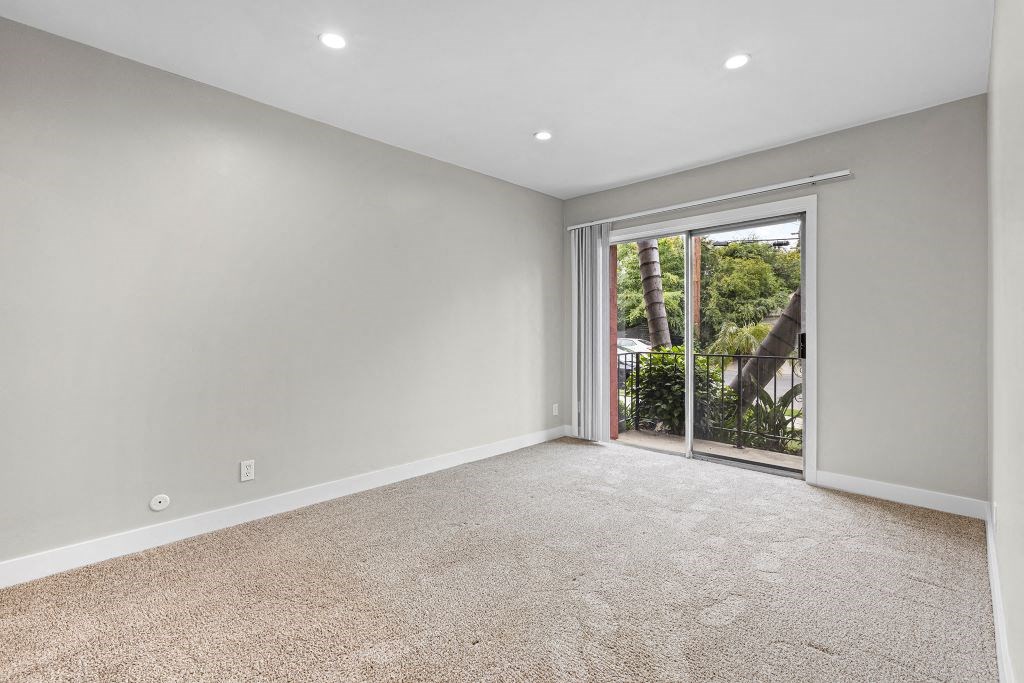 a bedroom with a sliding glass door leading to a balcony