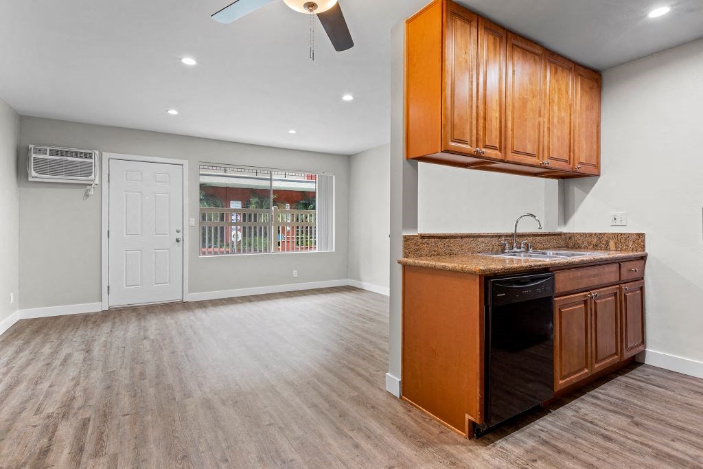 an empty kitchen and living room with a ceiling fan