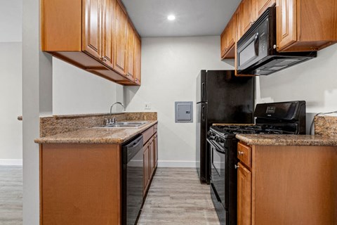 a kitchen with black appliances and wooden cabinets