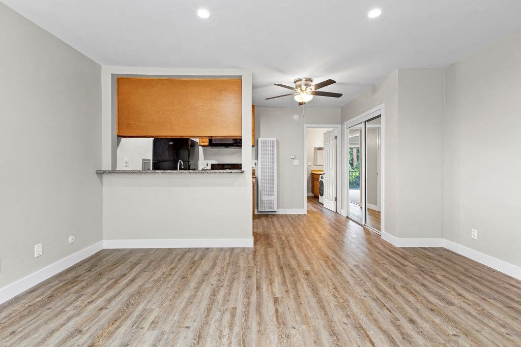 Apartments in Sherman Oaks CA - Parkview Terrace - A Vacant And Spacious Living Room With Wood-Style Flooring Facing towards the kitchen complete with bar-style seating area