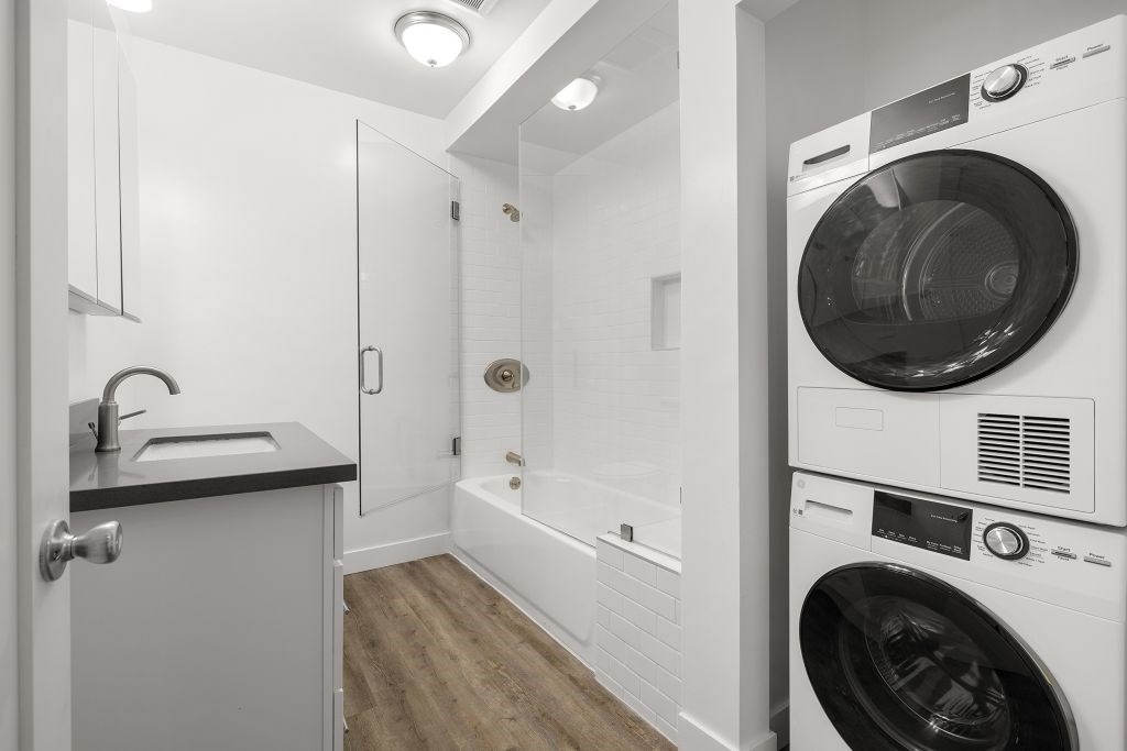 A laundry room with a washer and dryer stacked on top of each other.