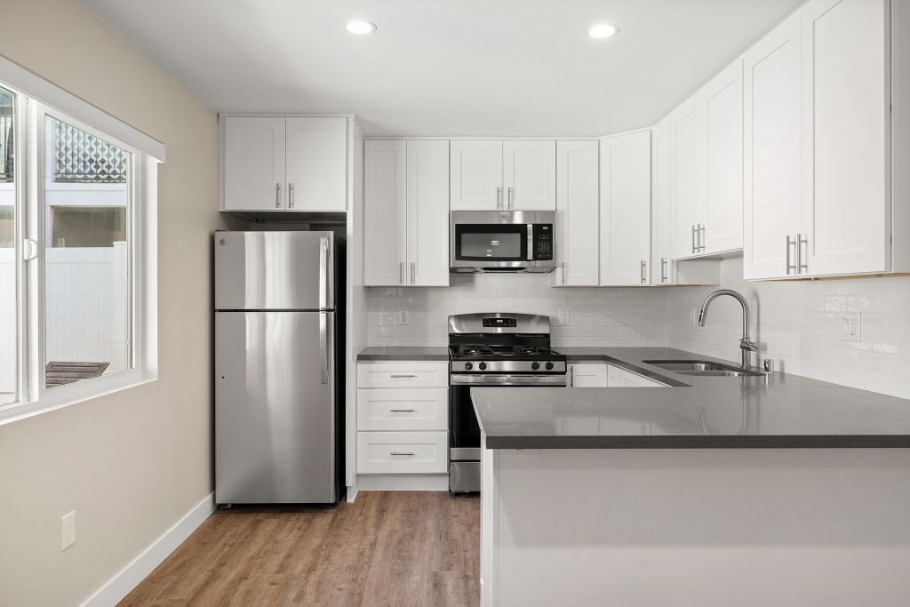 A modern kitchen with stainless steel appliances and white cabinets.