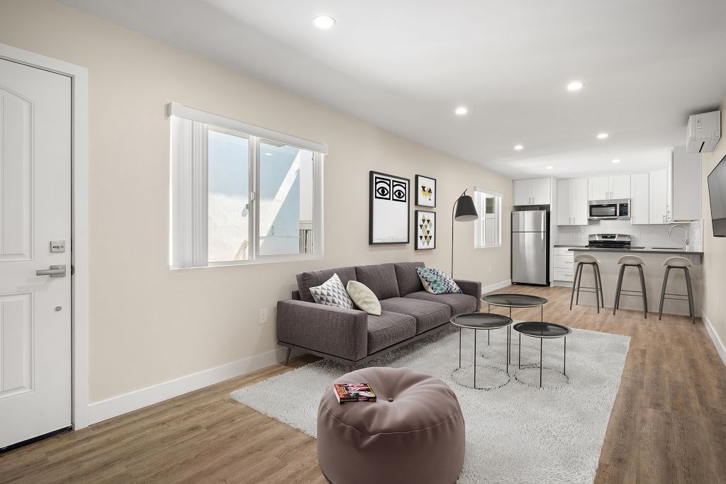 A modern living room with a grey couch and a white door.