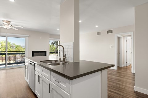 A modern kitchen with white cabinets and a black countertop.