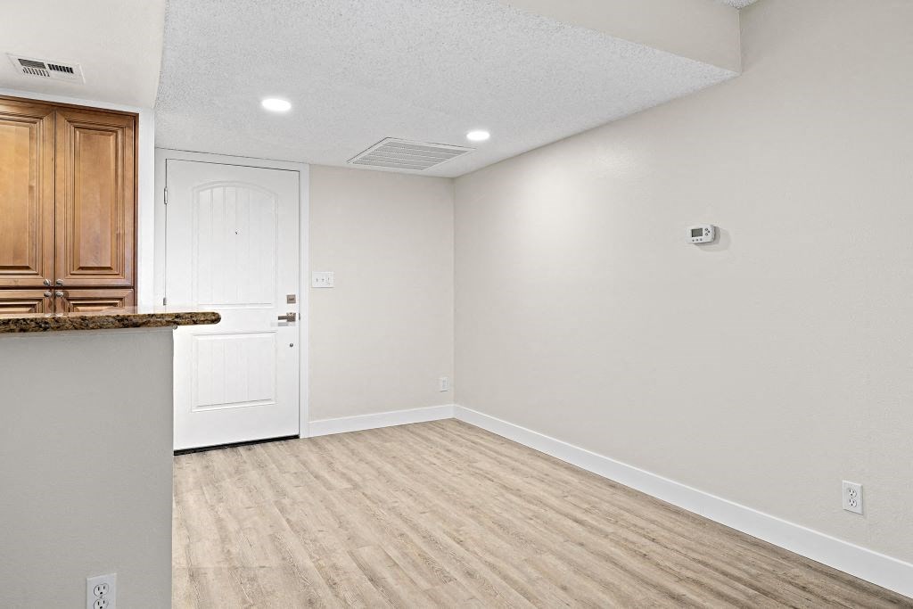 a kitchen and dining room with white walls and wood floors at Woodland Trio Apartments, North Hollywood