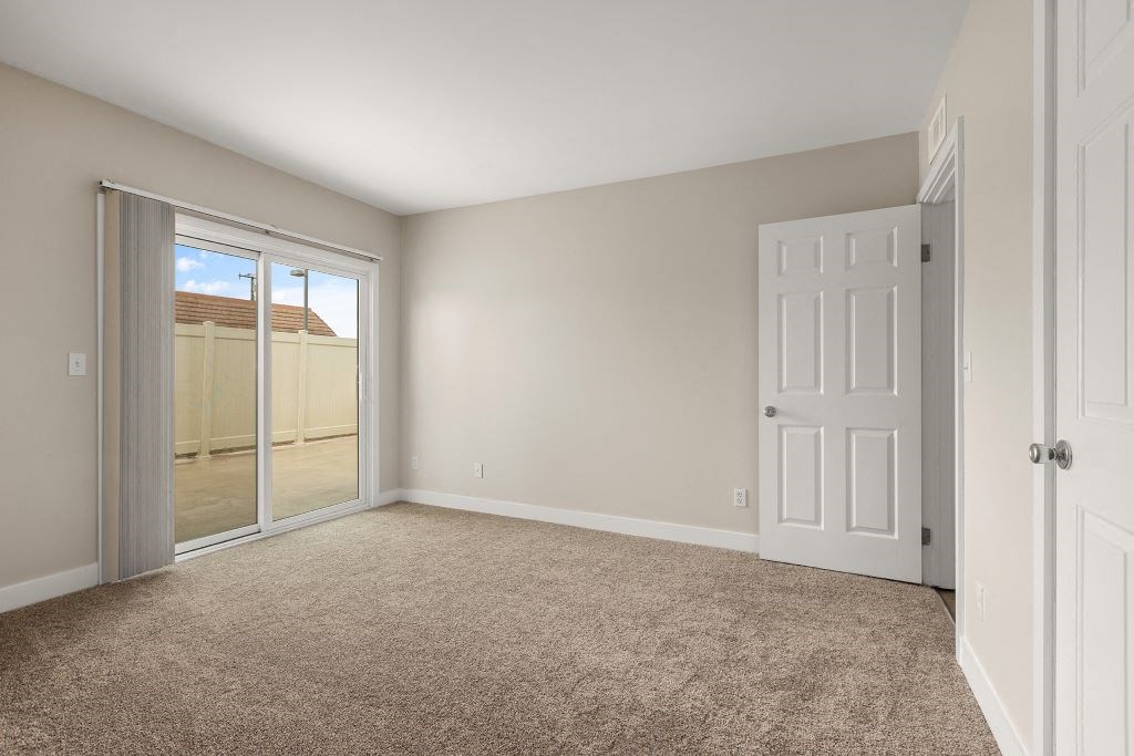 a bedroom with a door leading to a balcony