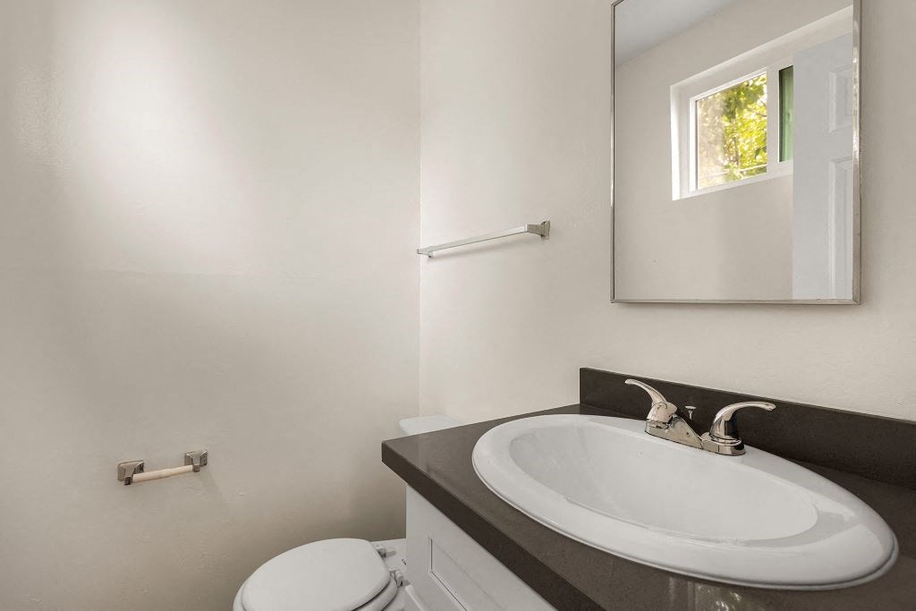 a bathroom with a sink toilet and mirror