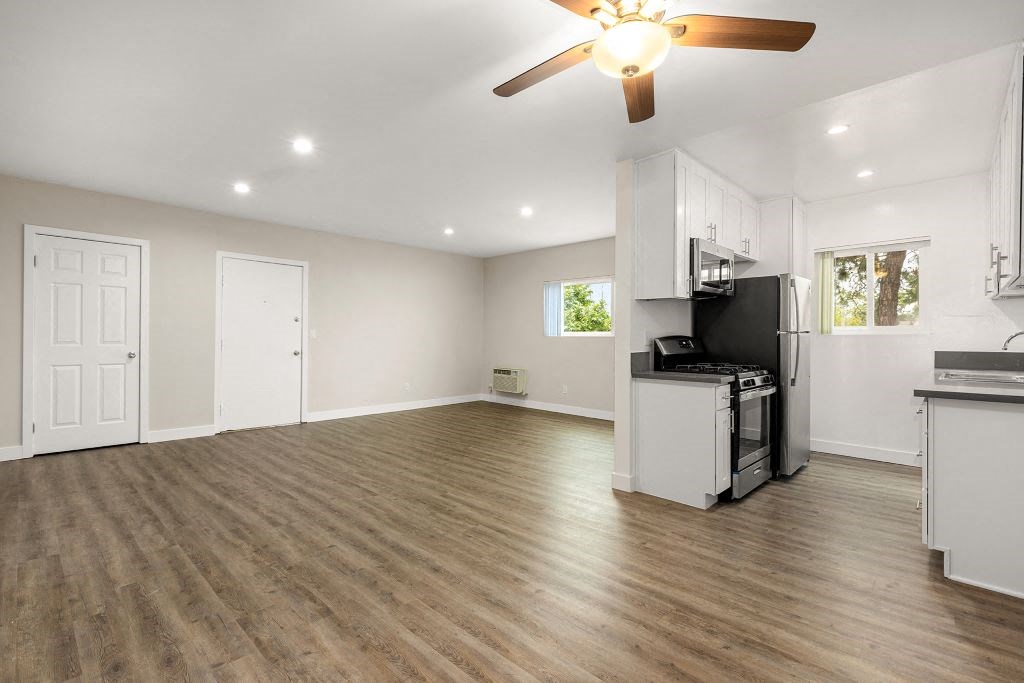 an empty kitchen and living room with a ceiling fan