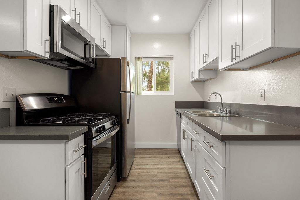 a kitchen with white cabinets and stainless steel appliances