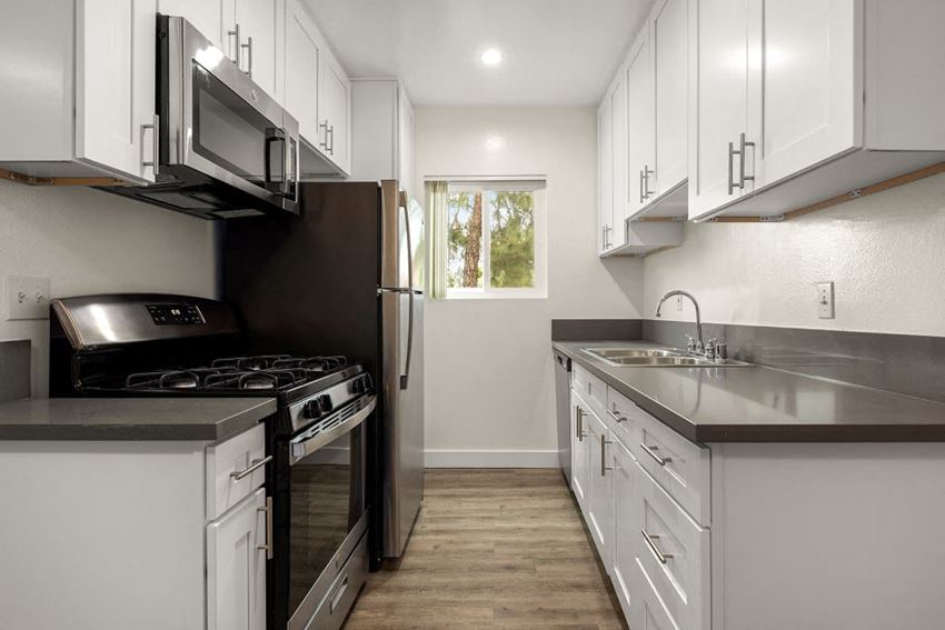 a kitchen with white cabinets and stainless steel appliances - Photo Gallery