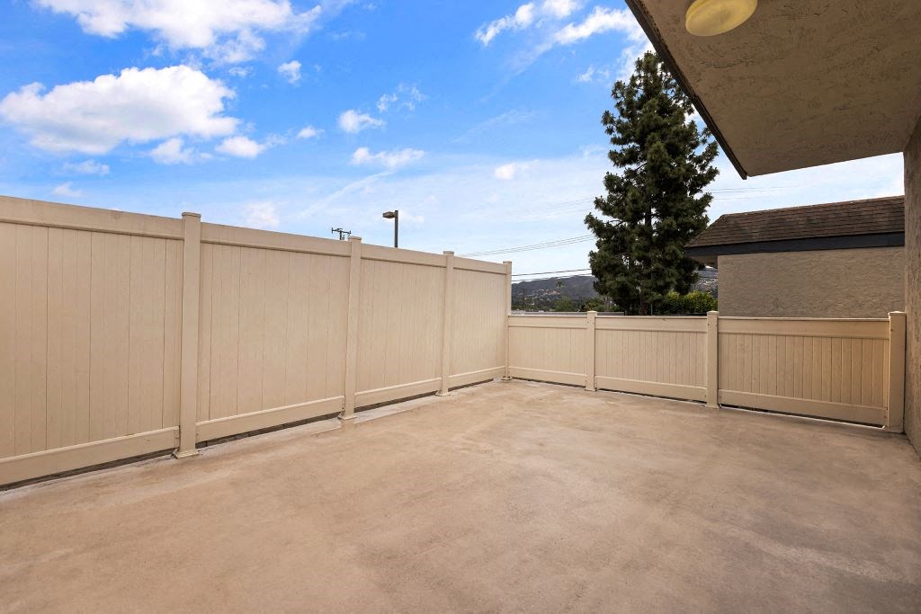 a balcony with a fence and a blue sky in the background