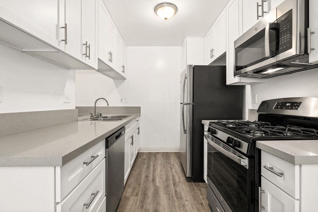 Kitchen with Stainless-Steel Appliances, Spacious Countertops, and White Cabinets at Casa De Marina Apartments, California