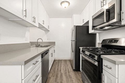 a kitchen with stainless steel appliances and white cabinets