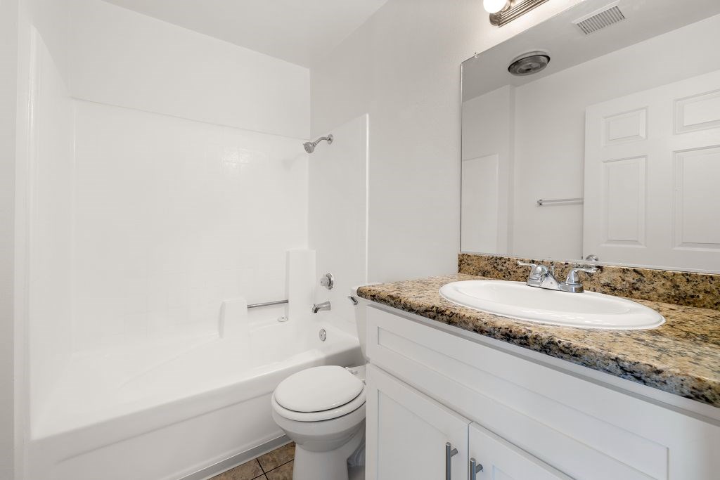 A white bathroom with a toilet, sink, and tub.