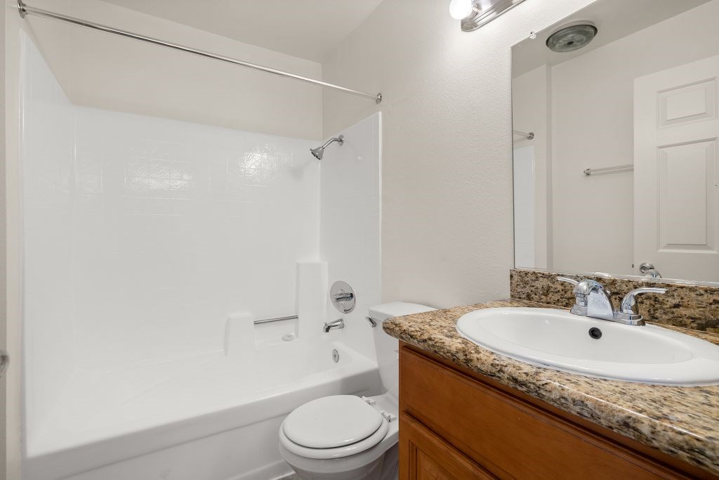A white toilet sits next to a sink in a bathroom.