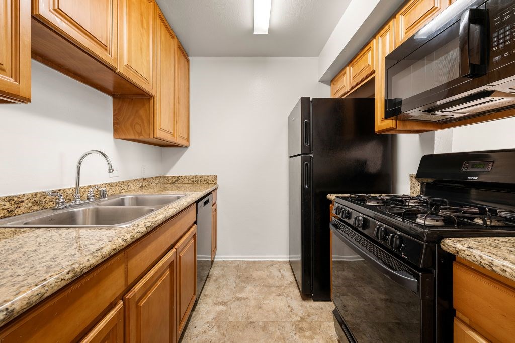 A kitchen with a black refrigerator and stove.