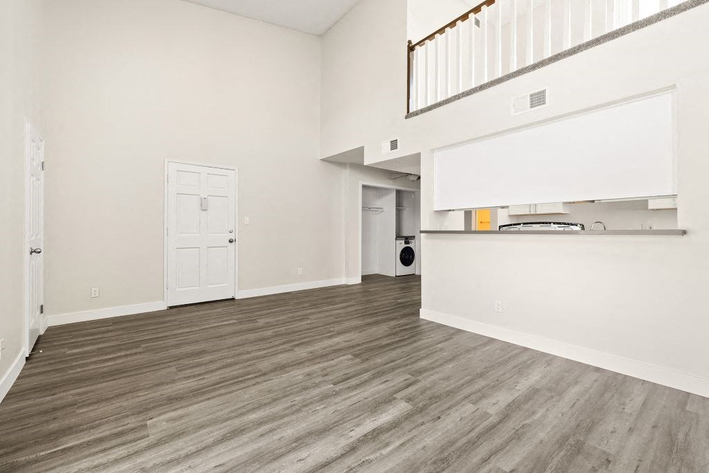 the living room and kitchen of a house with wood flooring