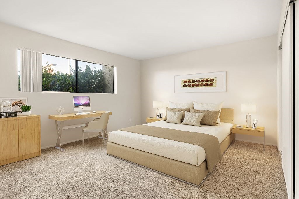 A bedroom with a bed, desk, and chair.