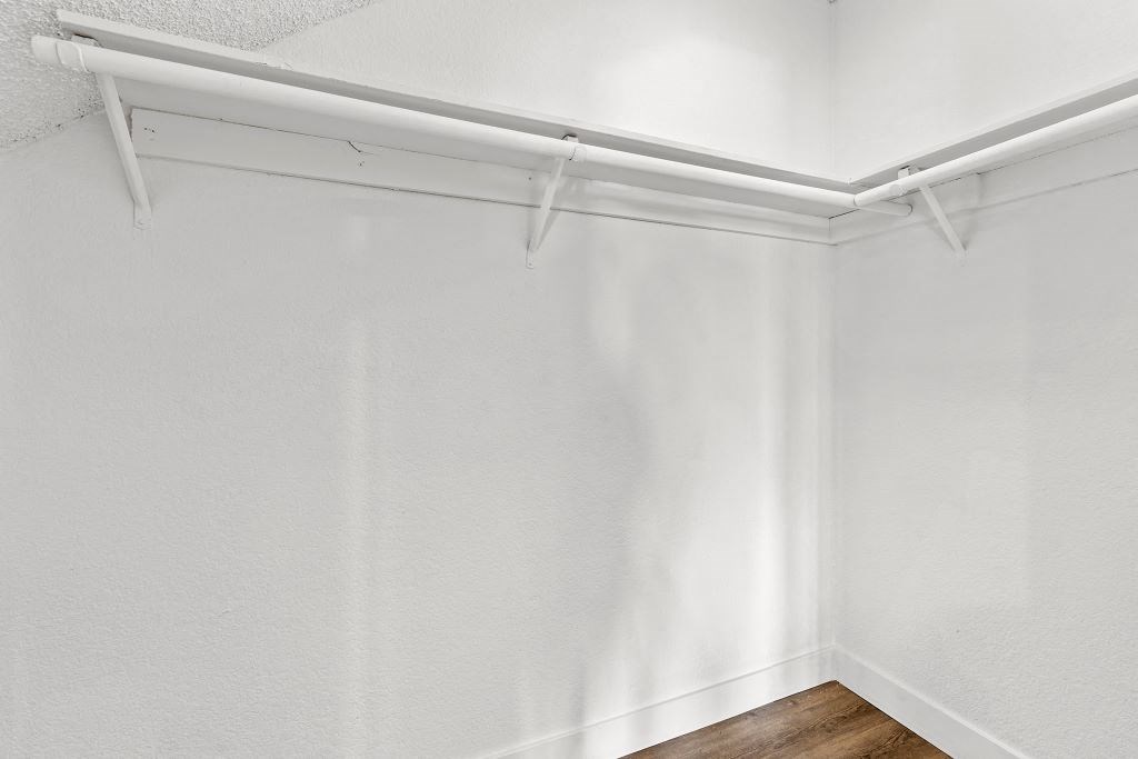 an empty room with white walls and a wooden floor