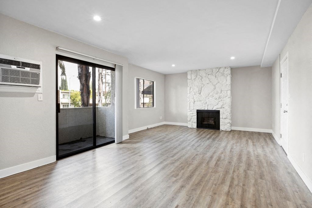 a living room with a fireplace and a glass door