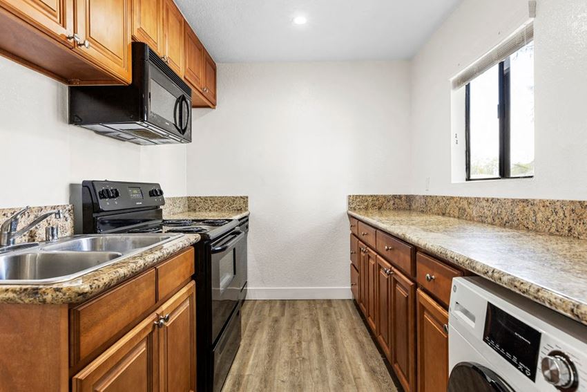 a kitchen with wood cabinets and granite countertops - Photo Gallery