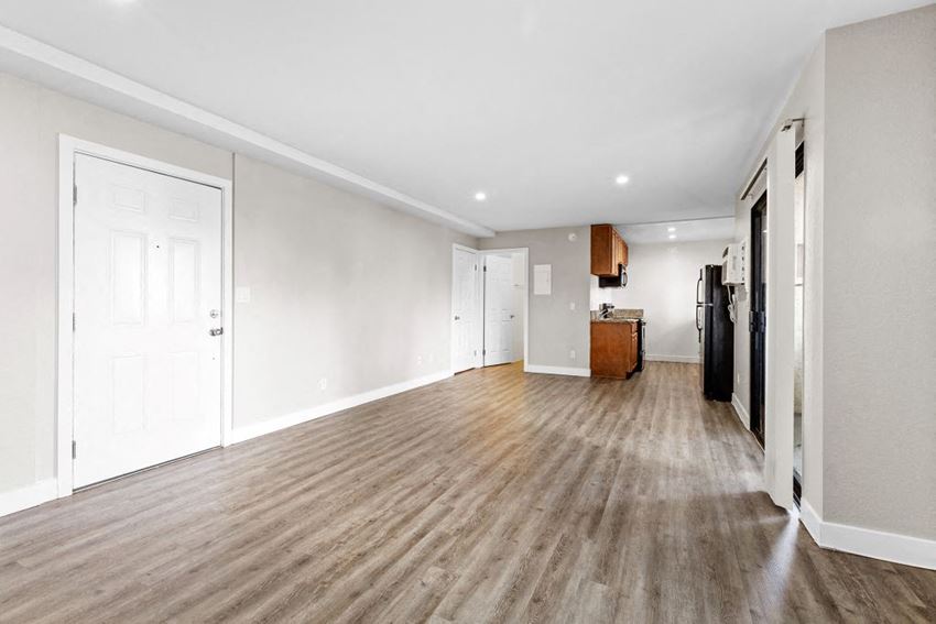 Studio Apartment a bedroom with a medium sized bed and a kitchen in the background - Photo Gallery