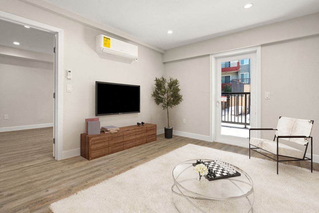 a living room with a tv and a table at Woodland Trio Apartments, North Hollywood, California