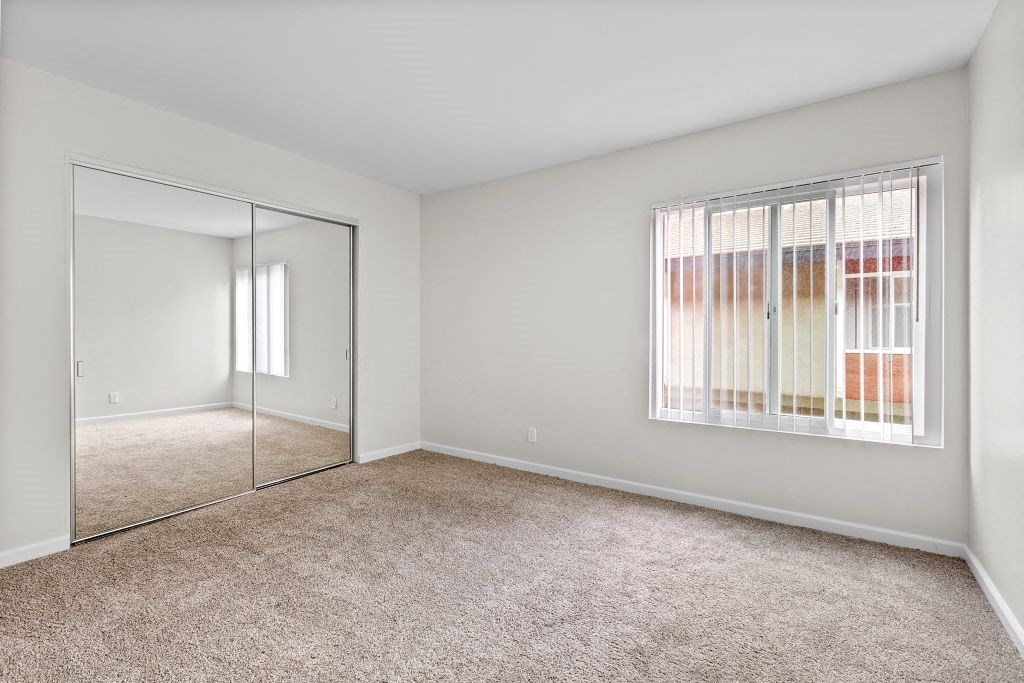 a bedroom with a large window and a mirror at The Meadows at The Meadows at Westlake Village Apartments,Westlake Village