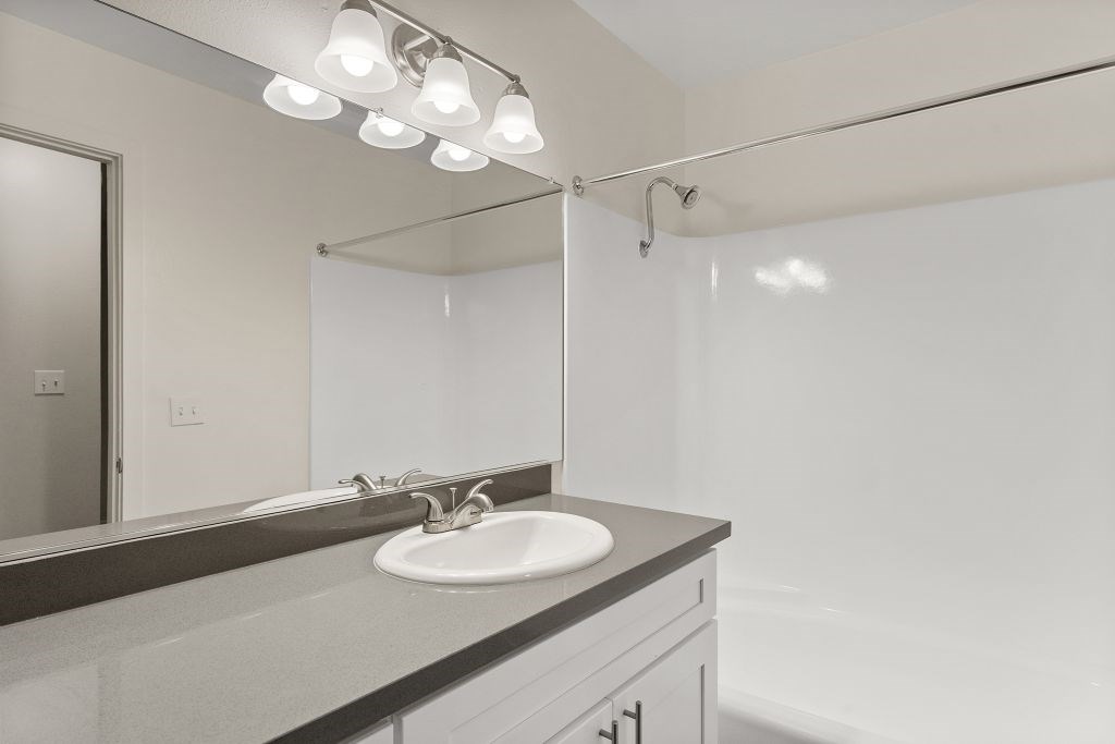 A bathroom with a sink and mirror.