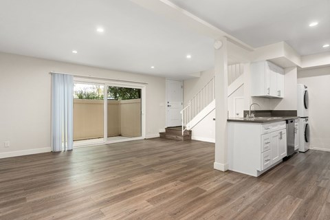 A kitchen with white cabinets and a wooden floor.