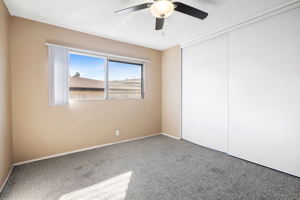 Carpeted bedroom with double closet doors.