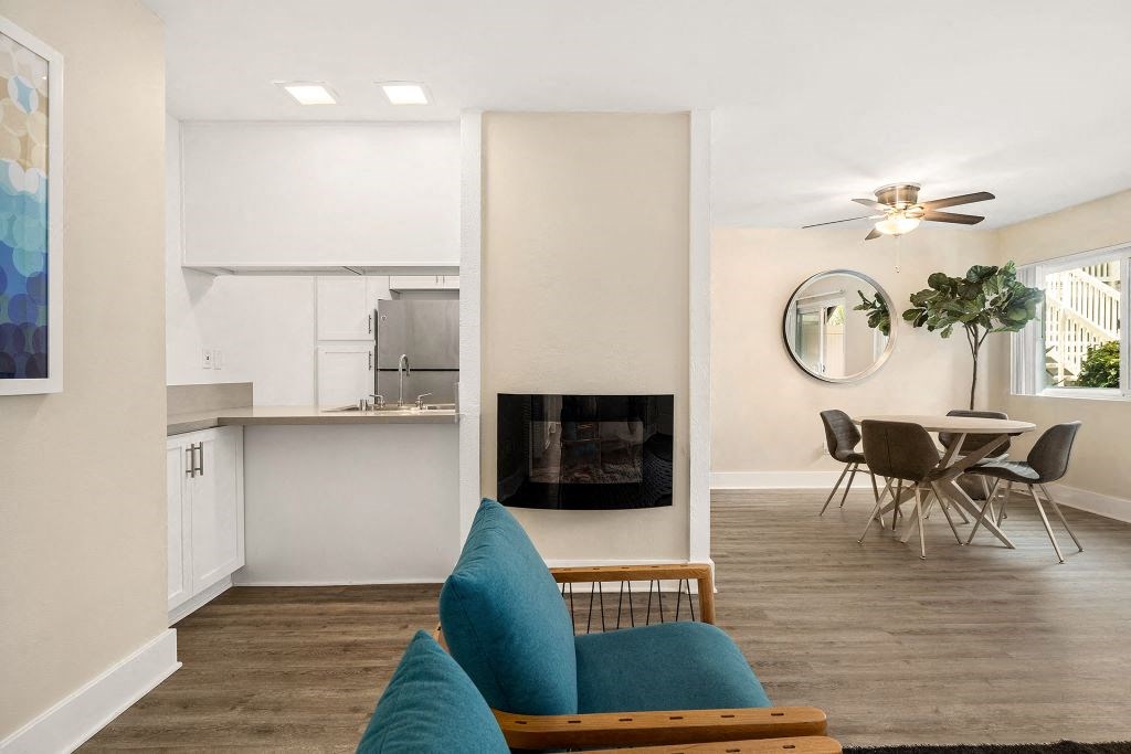Living Room Featuring Fireplace & Ceiling Fan With Kitchen And Dining Area in Background at Casa De Marina Apartments, Los Angeles, CA