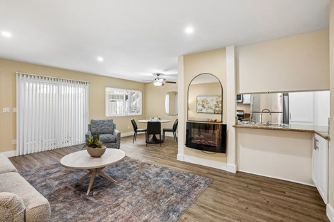 A living room with a fireplace and a dining table.
