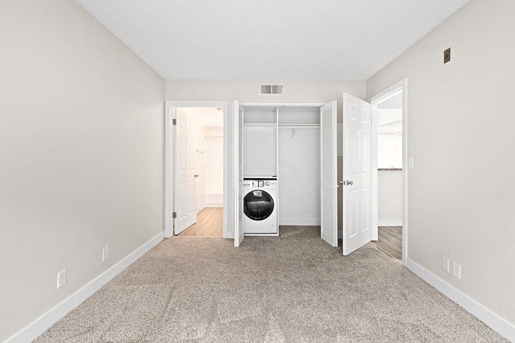 a bedroom with a washer and dryer at Woodland Trio Apartments, North Hollywood, CA