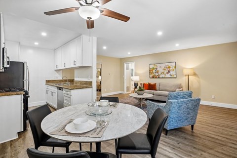 A modern kitchen with a dining table set for two.