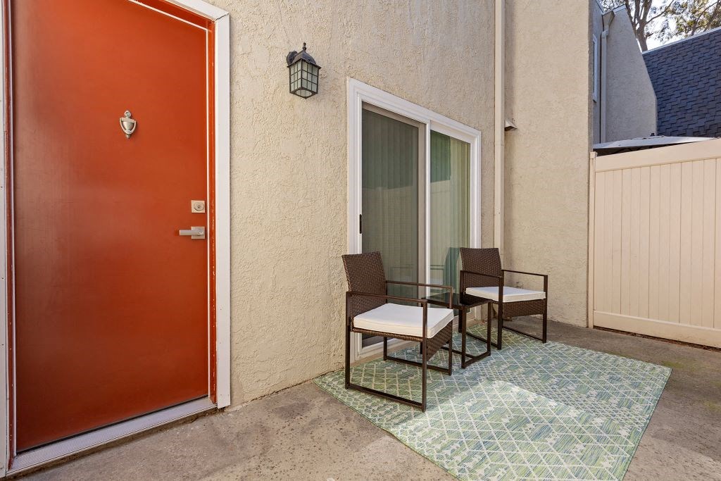 a patio with a red door and a table and chairs