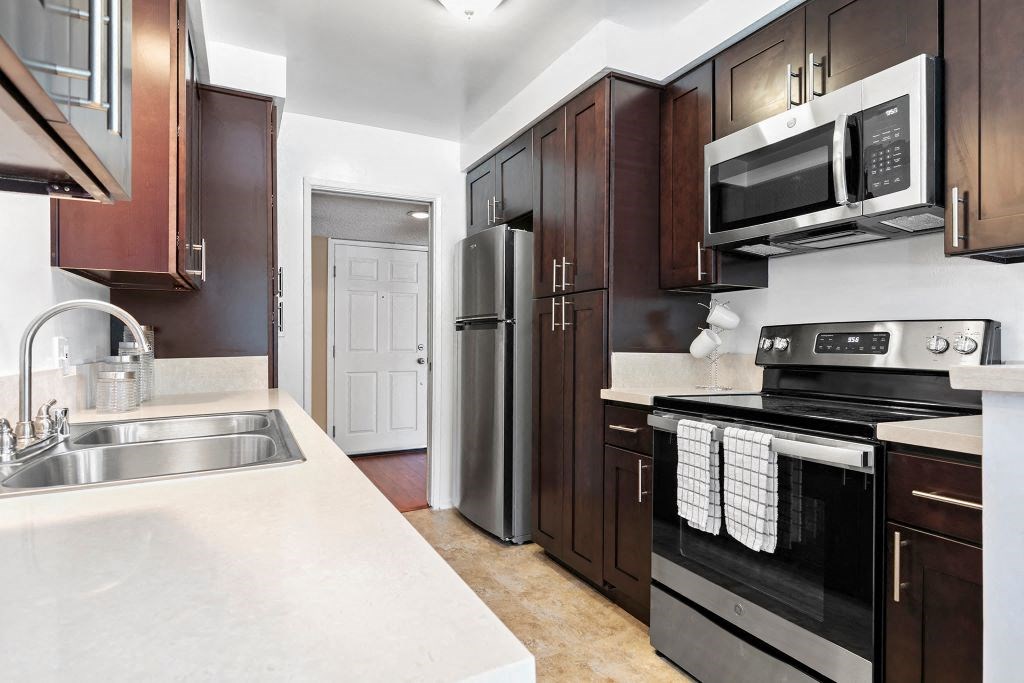 Apartments for Rent in Encino - Large Kitchen with Stainless Steel Appliances and Dark Brown Cabinets.
