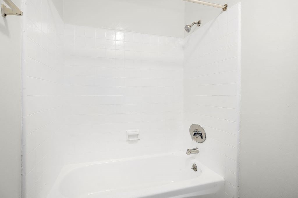 a white bath tub sitting next to a shower at Riverside Villas Apartments, California, 91602